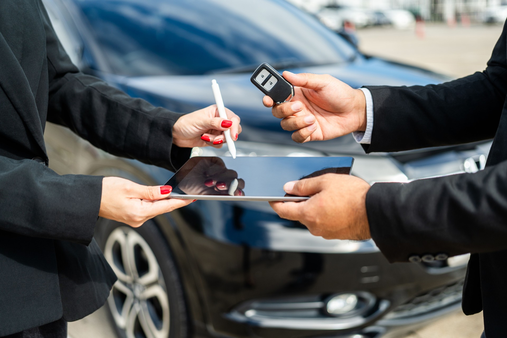 Young asian businesswoman buying new car with sale manager signing signature deal on tablet getting key and go to driving car. Buy sell rent concept. Hand sending key vehicle contract car deal